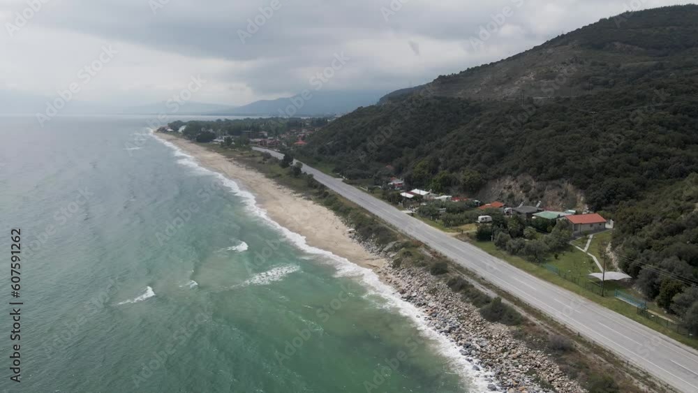 Aerial view of a road following a small empty beach along the Strymonian Gulf in the Aegean Sea, Nea Kerdylia, Central Macedonia, Greece. Aerial view of a road following a small empty beach along the Strymonian Gulf in the Aegean Sea, Nea Kerdylia, Central Macedonia, Greece.
