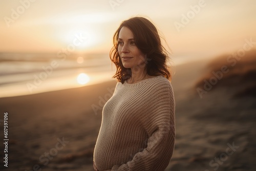 Portrait of a young beautiful pregnant woman on the beach at sunset