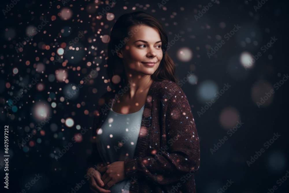 Portrait of a beautiful young woman on black background with falling snow