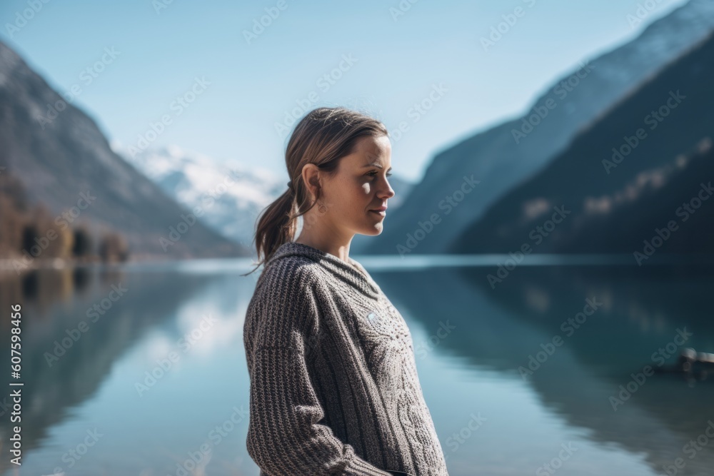 Beautiful young woman in sweater on the background of mountain lake. Beautiful young woman in sweater on the background of mountain lake.