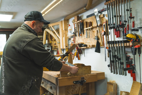 male carpenter creating wooden product by using a drawshape, medium shot, workshop. High quality photo