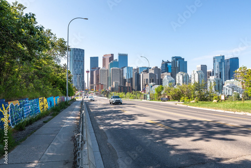 Views along Centre St Bridge in Calgary, Alberta on a blue sky day with city skyline in view, tower, sky scrapers in scenic skyscape landscape.  #607606440