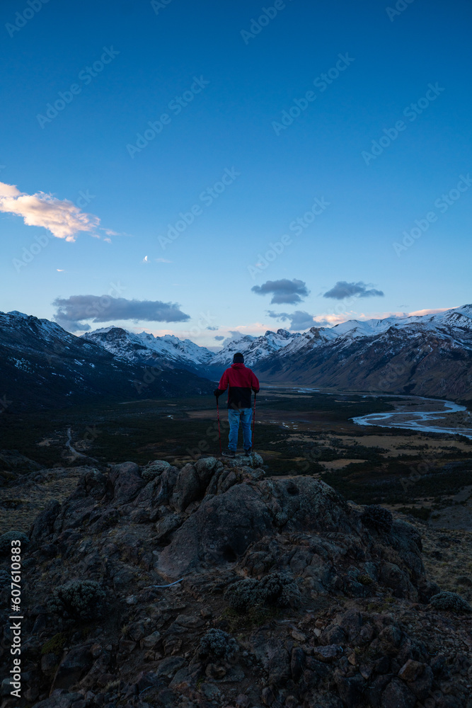 a man looking at the mountains during the blue hour