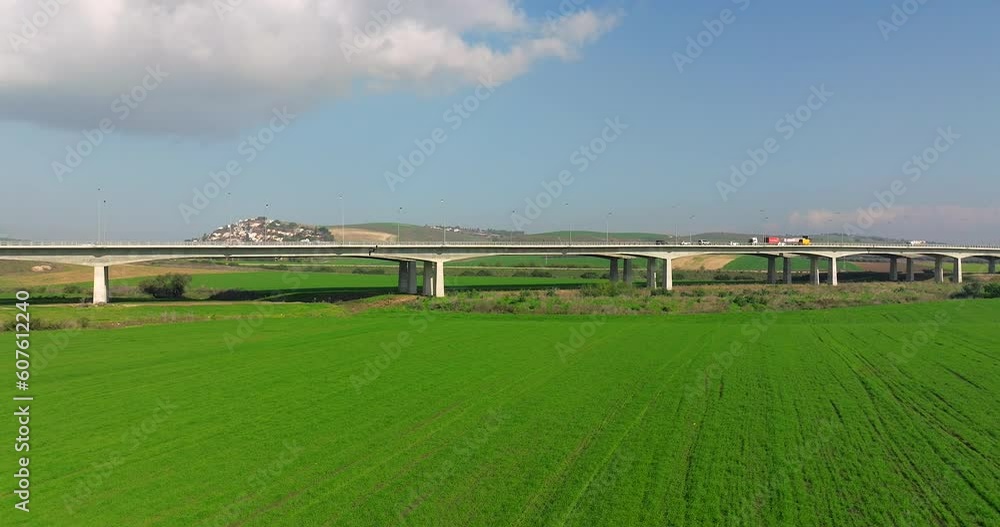 Aerial view of Day traffic on a countryside bridge surrounded by lush green landscape Aerial view of Day traffic on a countryside bridge surrounded by lush green landscape