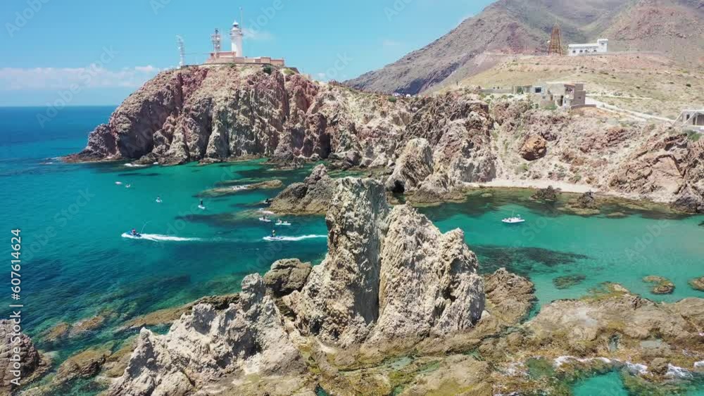 Aerial view of Faro de Cabo de Gata, a lighthouse along the wild coastline with cliffs, Almeria, Spain. Aerial view of Faro de Cabo de Gata, a lighthouse along the wild coastline with cliffs, Almeria, Spain.