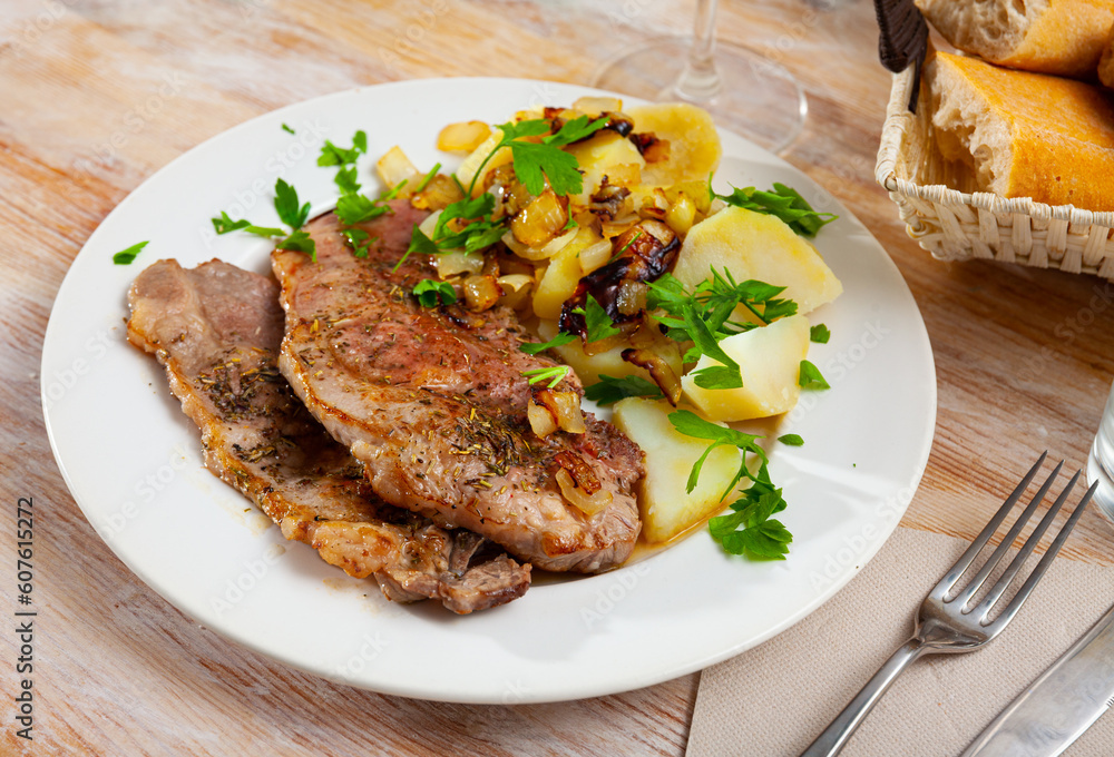 Grilled pork chop steak on plate served with boiled potatoes