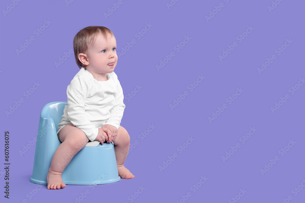 Little child sitting on baby potty against violet background, space for text Little child sitting on baby potty against violet background, space for text