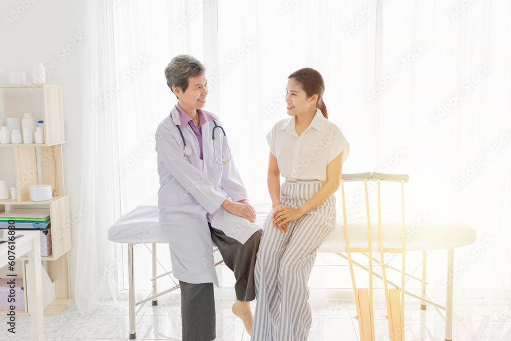 light and blur people, asian patient learning to use crutches with doctor, she training and rehabilitation, doctor assessment of patient leg light and blur people, asian patient learning to use crutches with doctor, she training and rehabilitation, doctor assessment of patient leg