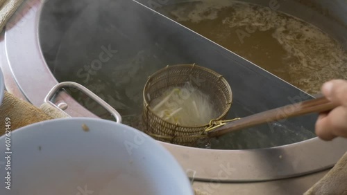 thai street restaurant Tom yum soup noodle making adding sprouts photo