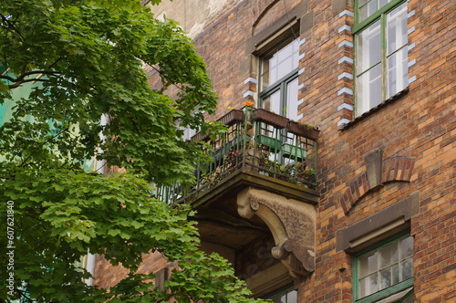 Balcony in an old building, surrounded by greenery. © Adam Bialek