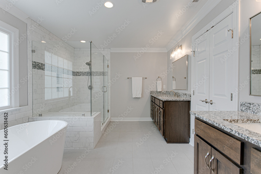Modern Interior of Primary Bathroom with Double Vanity, His and Her Sinks, and a White Floating Tub and Glass Luxury Soaking Shower Modern Interior of Primary Bathroom with Double Vanity, His and Her Sinks, and a White Floating Tub and Glass Luxury Soaking Shower