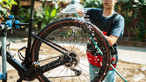 Asian bike mechanic washing a customer's bike. photo