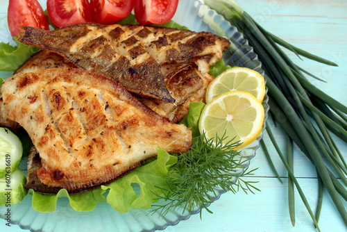 Canvastavla Grilled flounder fish with vegetables is on the plate.