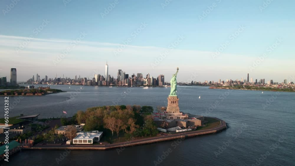 Long aerial of Liberty Island, statue of Liberty with Freedom Tower and ...