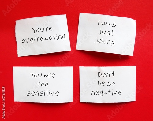 Billede på lærred On red background, paper pieces with handwriting YOU'RE OVER REACTING, I WAS JUS