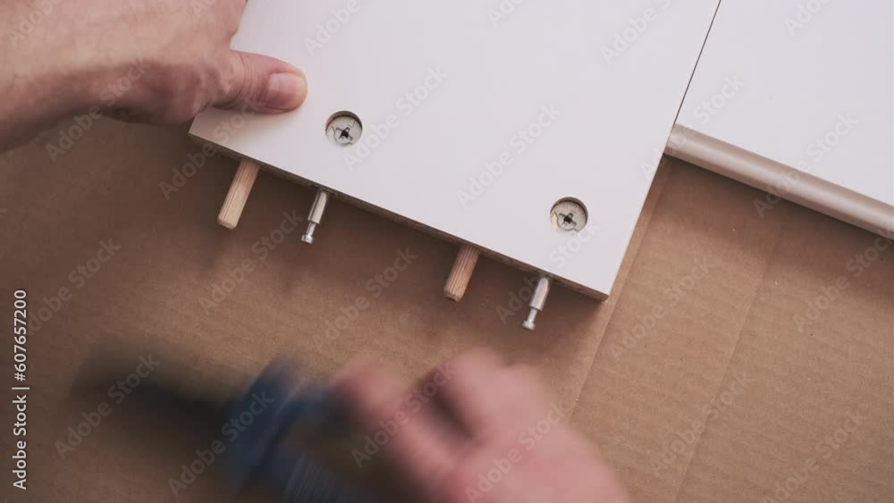 Furniture assembler inserted the shopper to wood. the interior room