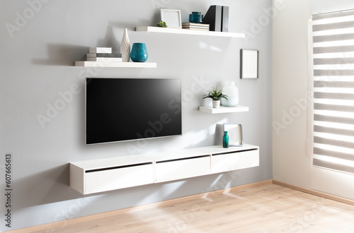 A modern tv room  flat-screen television is propped up on a bookshelf  surrounded by decorative items and framed photos