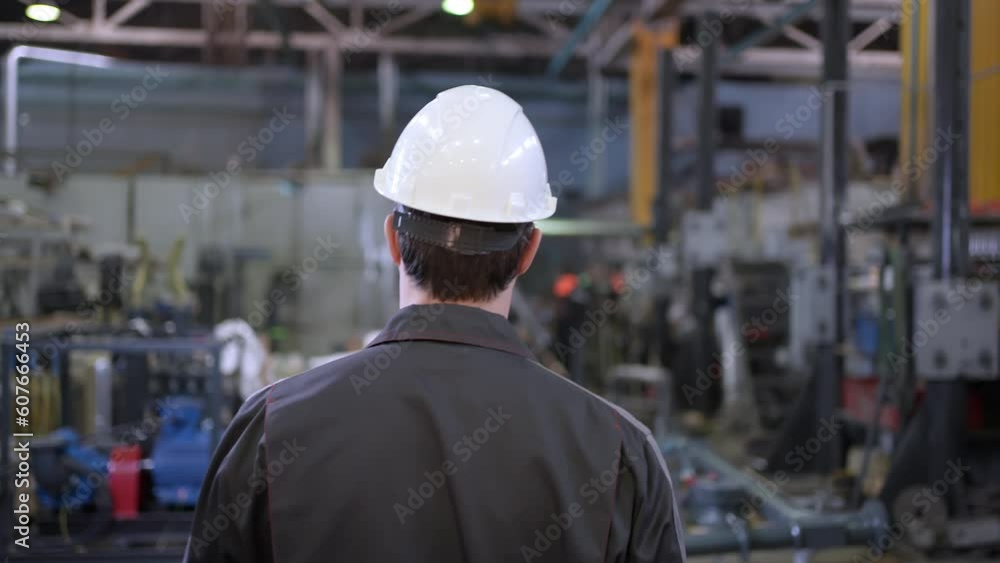 Follow of worker caucasian engineer man employee controls production process walking factory. Professional Heavy Industry Engineer Wearing Safety Uniform and Hard Hat in Metal Construction Manufacture Follow of worker caucasian engineer man employee controls production process walking factory. Professional Heavy Industry Engineer Wearing Safety Uniform and Hard Hat in Metal Construction Manufacture
