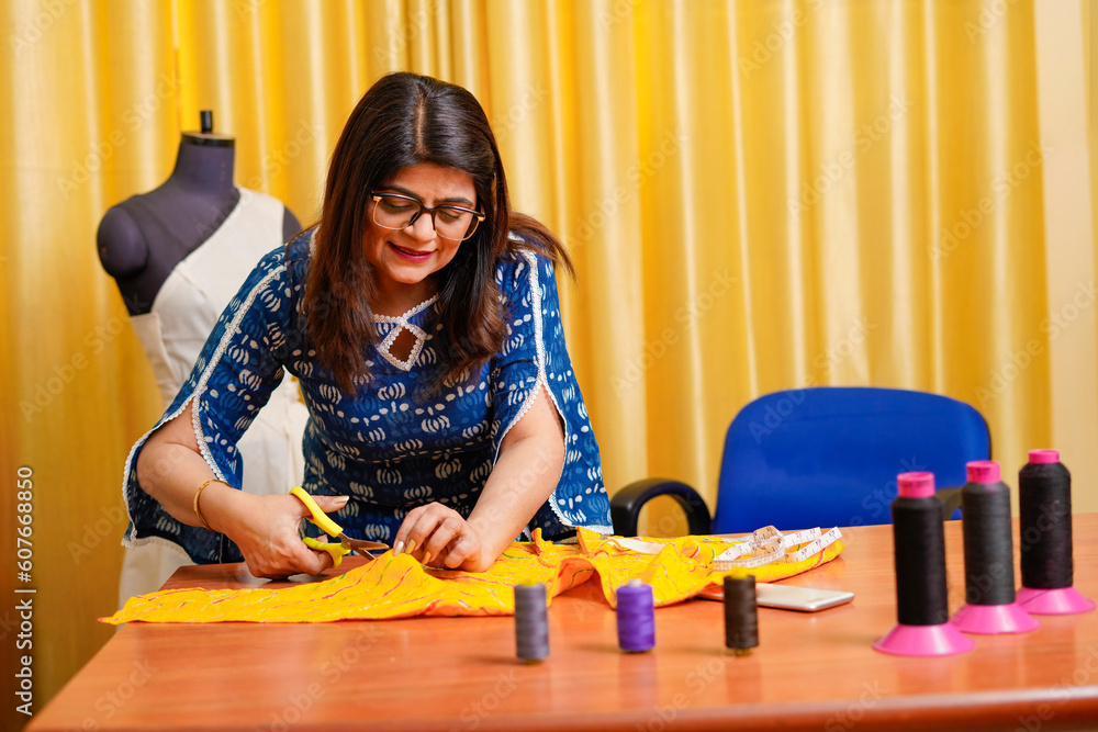 Indian female fashion designer working at her shop Indian female fashion designer working at her shop