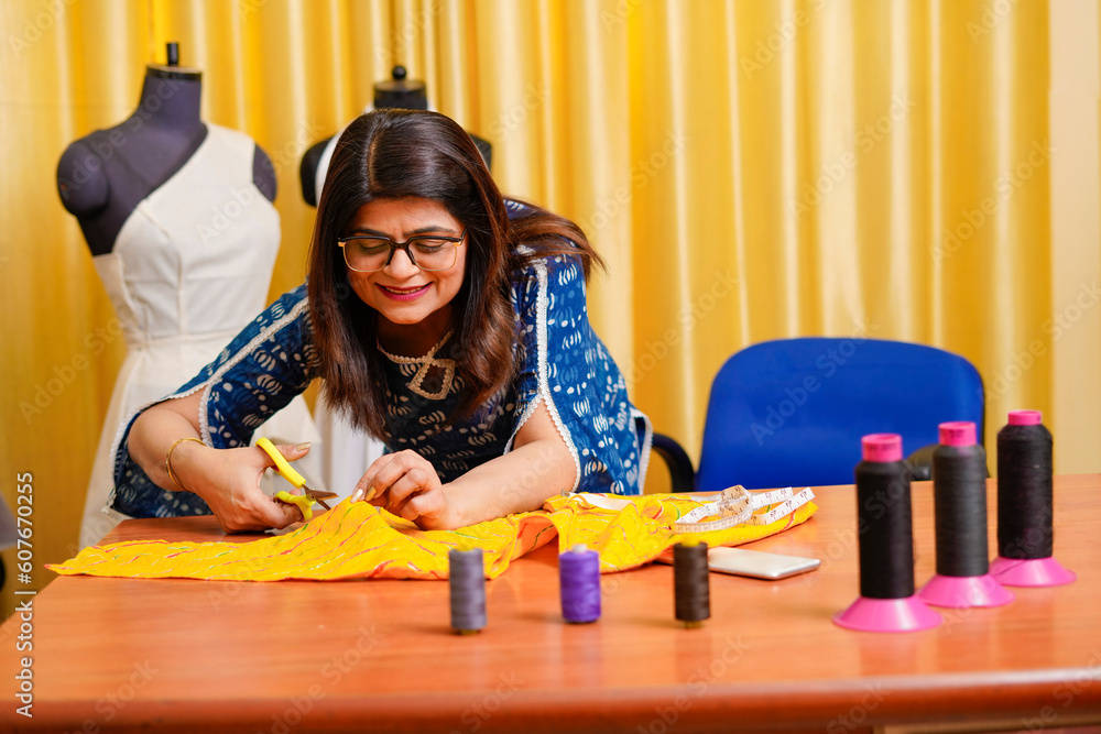 Indian female fashion designer working at her shop Indian female fashion designer working at her shop