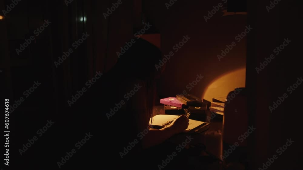 girl sitting at the table in the light of a lamp side view girl sitting at the table in the light of a lamp side view