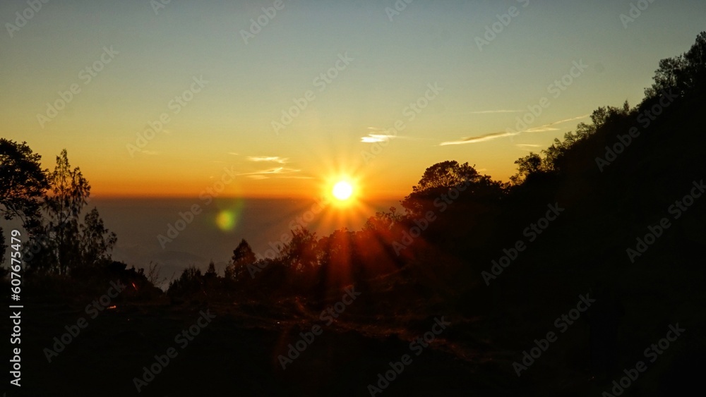 Obraz premium sunrise ambience in orange sky with silhouette of natural landscape