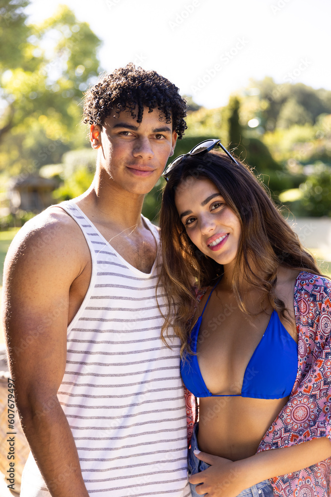 Portrait of smiling biracial young couple in swimwear standing against clear sky Portrait of smiling biracial young couple in swimwear standing against clear sky