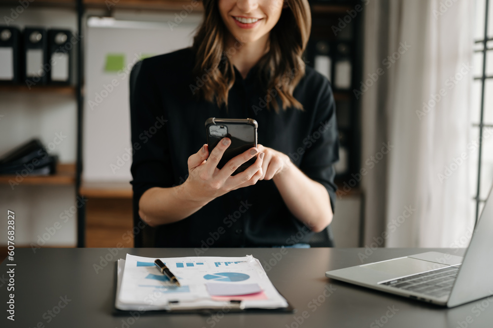business documents on office table with smart phone and digital tablet and graph financial and woman working at office. business documents on office table with smart phone and digital tablet and graph financial and woman working at office.