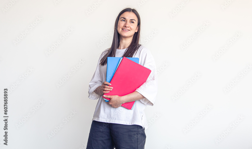 Young woman with colorful notepads on a white background, copy space. Young woman with colorful notepads on a white background, copy space.