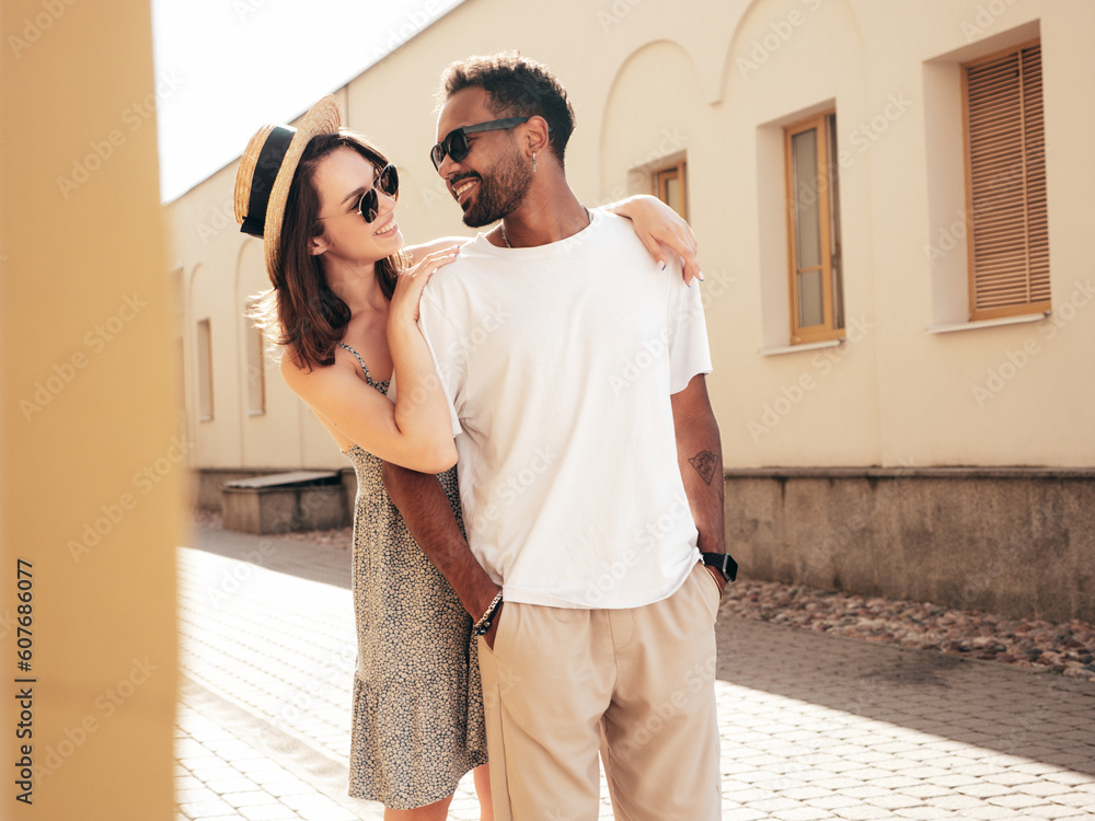 Smiling beautiful woman and her handsome boyfriend. Woman in casual summer  clothes. Happy cheerful family. Female having fun. Sexy couple posing in  the street at sunny day. In hat and sunglasses Stock