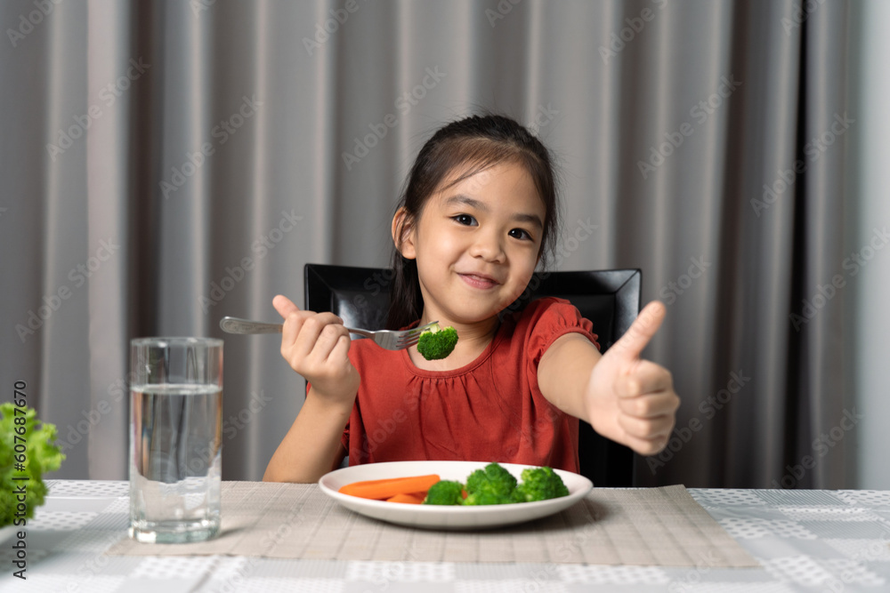 Cute little girl showing thumb showing eating healthy vegetables. Cute little girl showing thumb showing eating healthy vegetables.