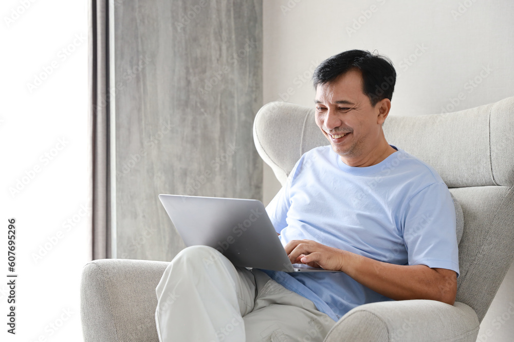 Smart and active asian sitting on sofa and using internet on computer in living room. Lifestyle and relaxation with technology Smart and active asian sitting on sofa and using internet on computer in living room. Lifestyle and relaxation with technology