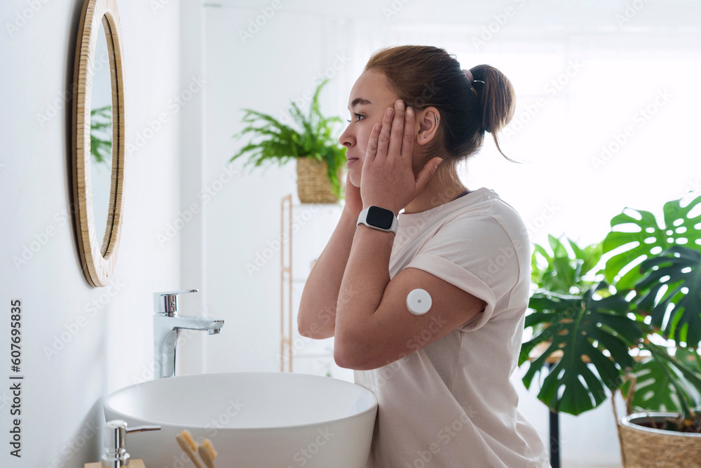 Woman with diabetes touching face in bathroom at home Stock Photo