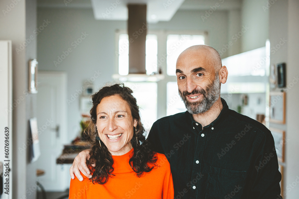Smiling man with arm around happy woman at home Smiling man with arm around happy woman at home