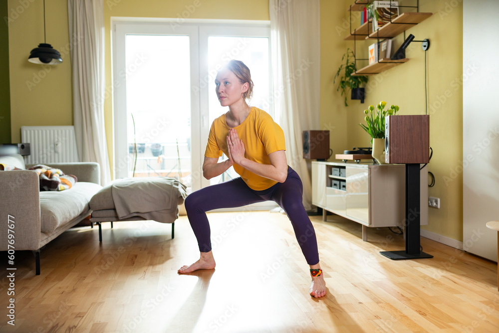 Young woman practicing yoga with hands clasped at home Young woman practicing yoga with hands clasped at home
