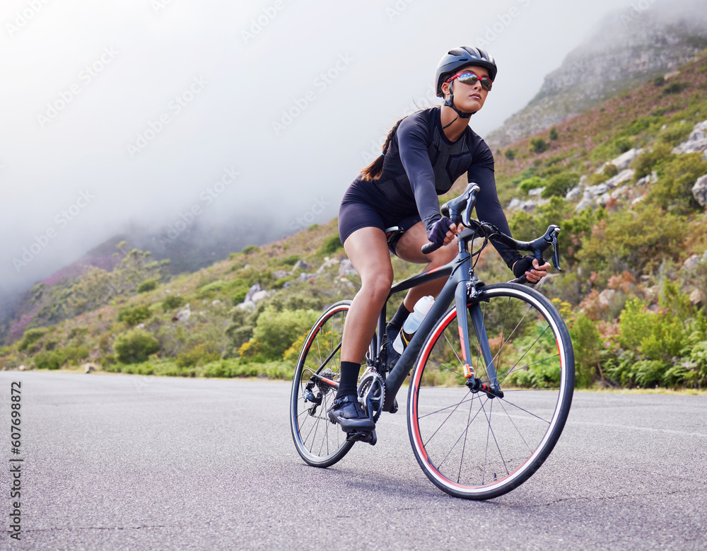 Road, woman and cycling with fitness, health and training for wellness, cardio and endurance. Female person, biker and cyclist with workout, street and practice with a helmet, glasses and exercise