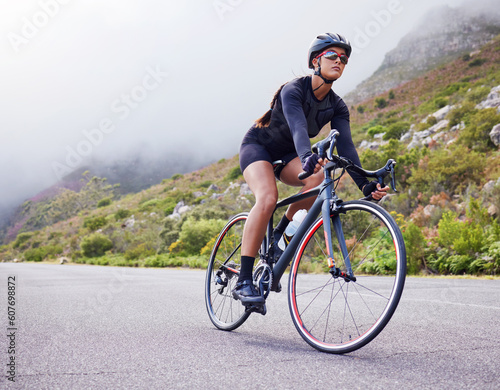 Fototapeta Naklejka Na Ścianę i Meble -  Road, woman and cycling with fitness, health and training for wellness, cardio and endurance. Female person, biker and cyclist with workout, street and practice with a helmet, glasses and exercise