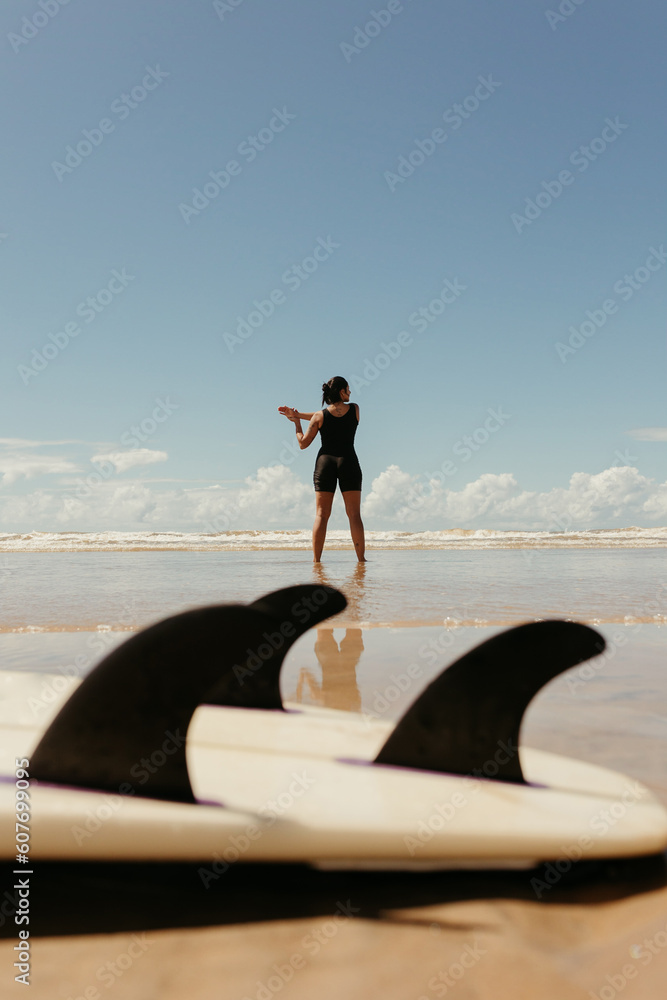 Naklejka premium woman with her surfboard on the beach