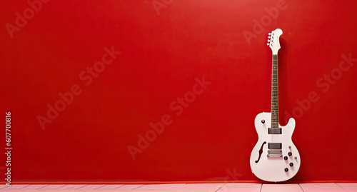 Frontal view of a white electric guitar hanging out of a red background.