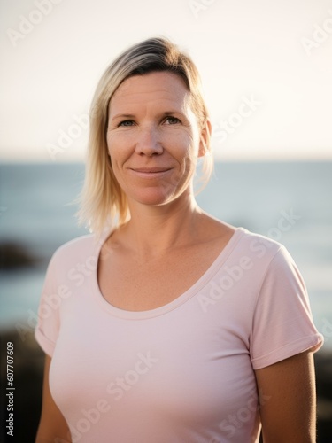 Free Download Portrait of mature woman standing on beach and looking at camera during sunset - GFXLoad
