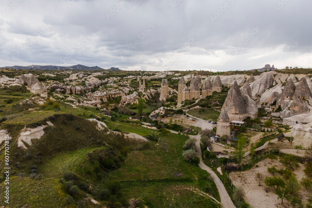 Aerial view of Goreme Valley and National Park with fairy chimney rock formation with Uchisar town in background Cappadocia, Nevsehir, Turkey.