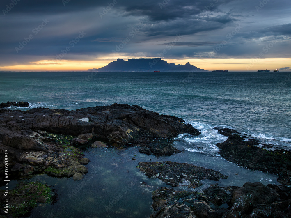 Aerial view of Table Mountain with moody sunrise from Bloubergstrand popular tourist travel destination, Cape Town, South Africa. Aerial view of Table Mountain with moody sunrise from Bloubergstrand popular tourist travel destination, Cape Town, South Africa.