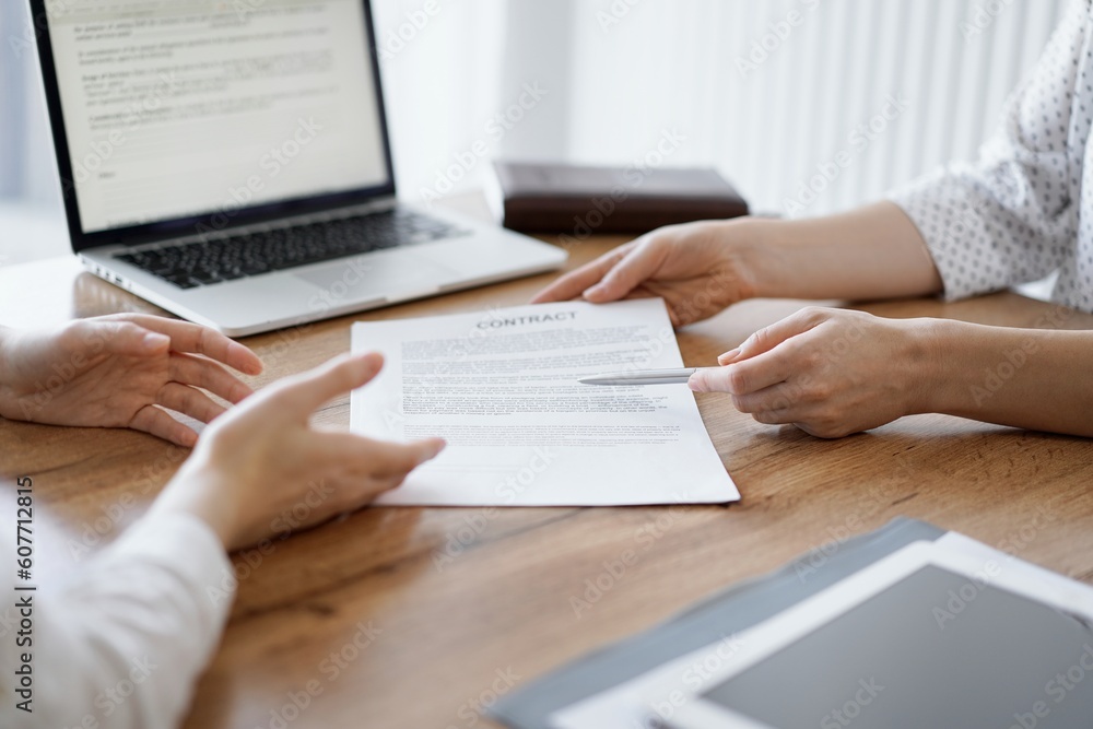 Businesswoman lawyer pointing into contract special points admitting something for colleague or client at the wooden desk in office. Business people teamwork and partnership, meeting concept. Businesswoman lawyer pointing into contract special points admitting something for colleague or client at the wooden desk in office. Business people teamwork and partnership, meeting concept.