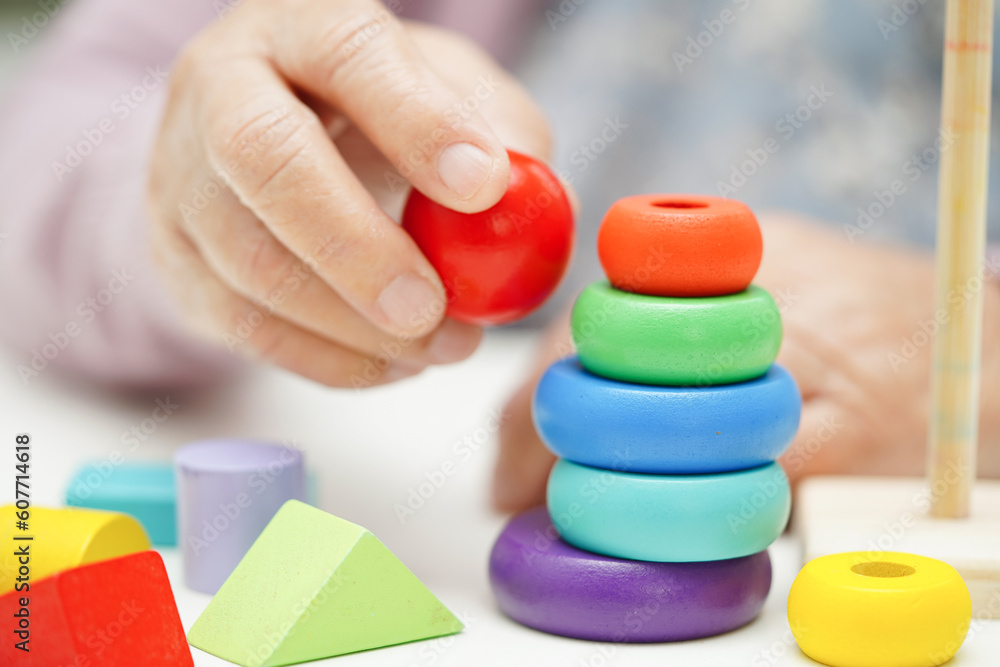 Asian elderly woman playing puzzles game to practice brain training for dementia prevention, Alzheimer disease.