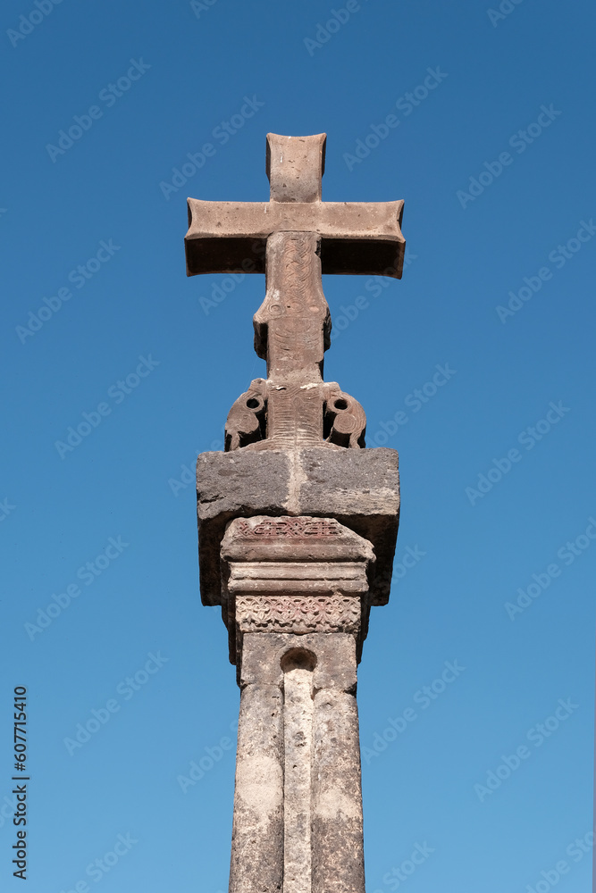Medieval column with cross on sunny summer day. Hovhannavank monastery, Aragatsotn Province, Armenia.
