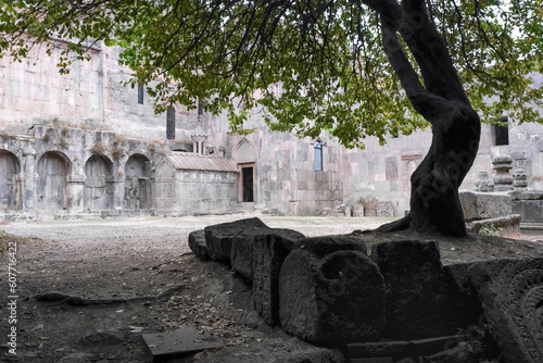 Remains of khachkars under the tree in Tatev Monastery inner yard on cloudy autumn morning. Tatev, Syunik Province, Armenia. photo