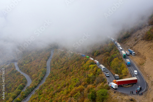 Drone view of traffic jam on hairpin turn on foggy autumn morning. Tatev, Syunik Province, Armenia.