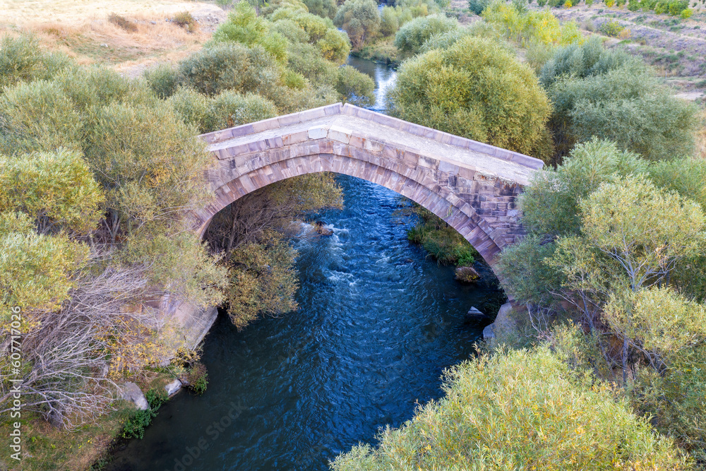 Drone view of medieval Dadal bridge across Arpa river on autumn evening. Yeghegnadzor, Vayots Dzor Province, Armenia. Drone view of medieval Dadal bridge across Arpa river on autumn evening. Yeghegnadzor, Vayots Dzor Province, Armenia.