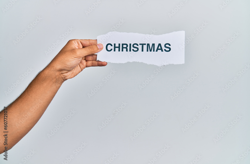 Hand of caucasian man holding paper with christmas word over isolated white background Hand of caucasian man holding paper with christmas word over isolated white background