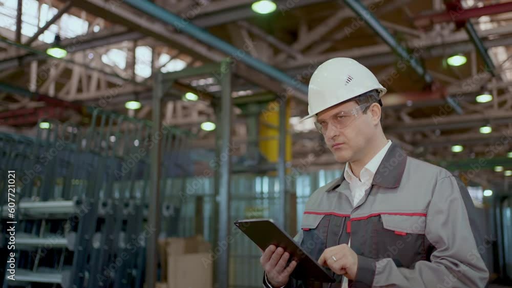 Engineer man walking Heavy industry plant with Technology tablet computer, Professional worker wearing Safety Uniform Hard Hat Industrial Specialist checking production metal construction Manufacture Engineer man walking Heavy industry plant with Technology tablet computer, Professional worker wearing Safety Uniform Hard Hat Industrial Specialist checking production metal construction Manufacture
